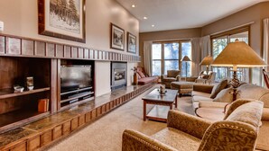 A spacious living room with a fireplace, comfortable seating, and large windows. - Quicksilver 1662 (Keystone)
