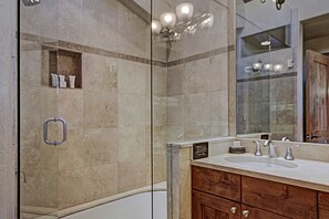 A modern bathroom with a glass shower enclosure, a wooden vanity with a double sink, and a large mirror. - Modern 2 BR Condo Lodge at Vail, Walk to Gondola by RedAwning (Vail)