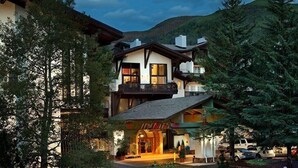 A multi-story chalet with a balcony, surrounded by trees and a mountain backdrop. - Modern 2 BR Condo Lodge at Vail, Walk to Gondola by RedAwning (Vail)