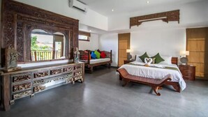 Um quarto espaçoso com uma cama grande, uma cômoda de madeira e um espelho decorativo.