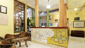 A reception area with a wooden reception desk, a map on the wall, and a brown sofa.
