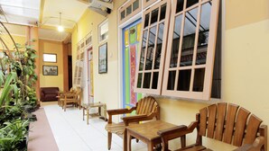 A hallway with wooden furniture, a plant area, and a colorful door.