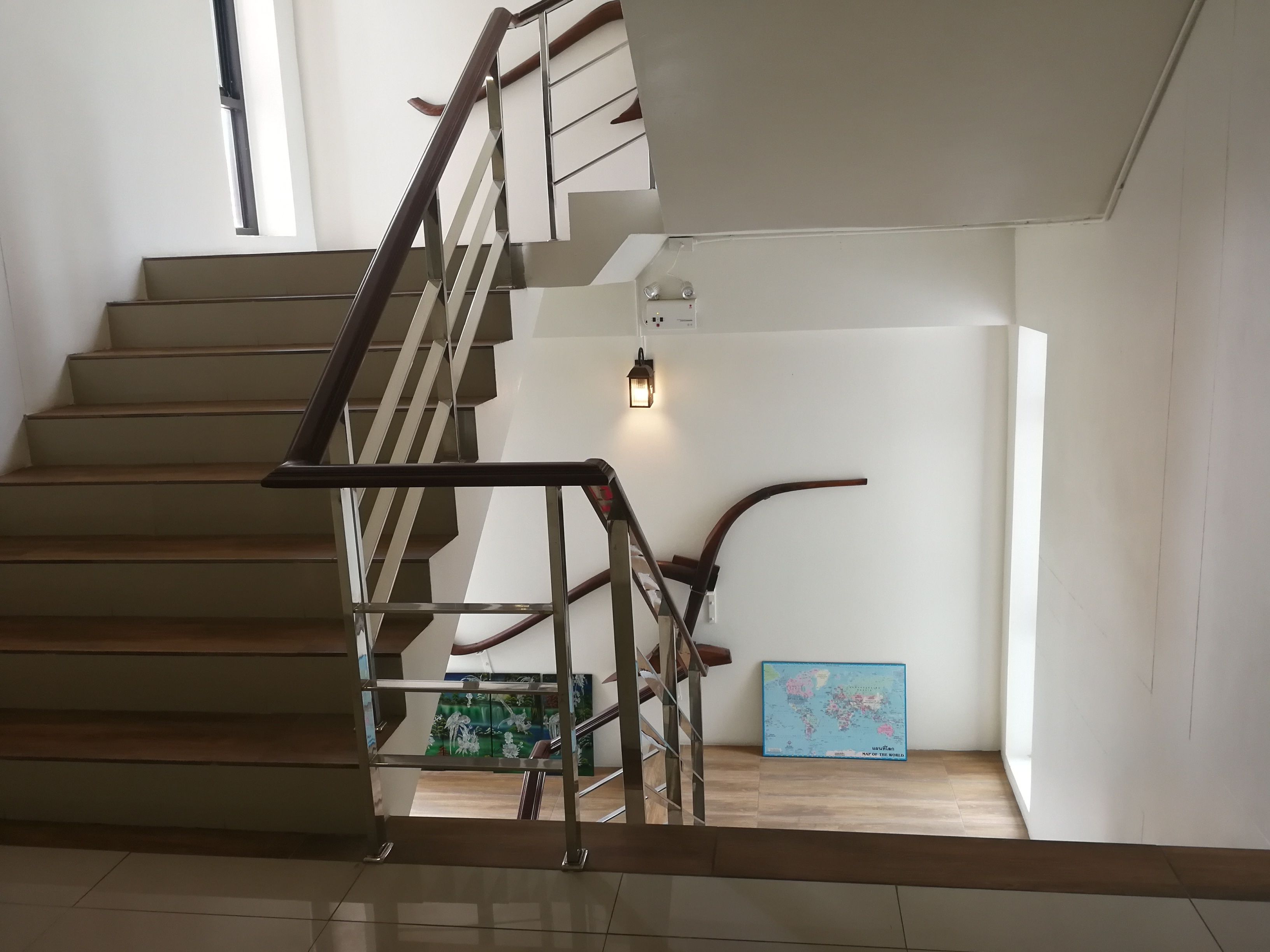 A modern staircase with metal railings and wooden steps.