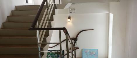 A modern staircase with metal railings and wooden steps.