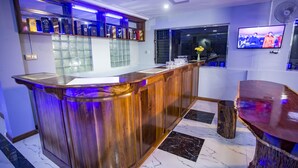 Angolo bar con un bancone in legno, una TV a parete e una finestra con vista.