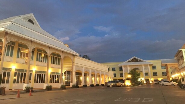 A hotel with a large central building and smaller wings, featuring arched windows and a symmetrical facade. - Amonruk  Hotel 2 (Phrae)
