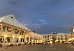 A hotel with a large central building and smaller wings, featuring arched windows and a symmetrical facade. - Amonruk  Hotel 2 (Phrae)