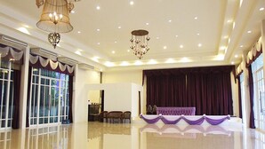 A spacious hall with a stage, chandeliers, and a polished floor. - Amonruk  Hotel 2 (Phrae)