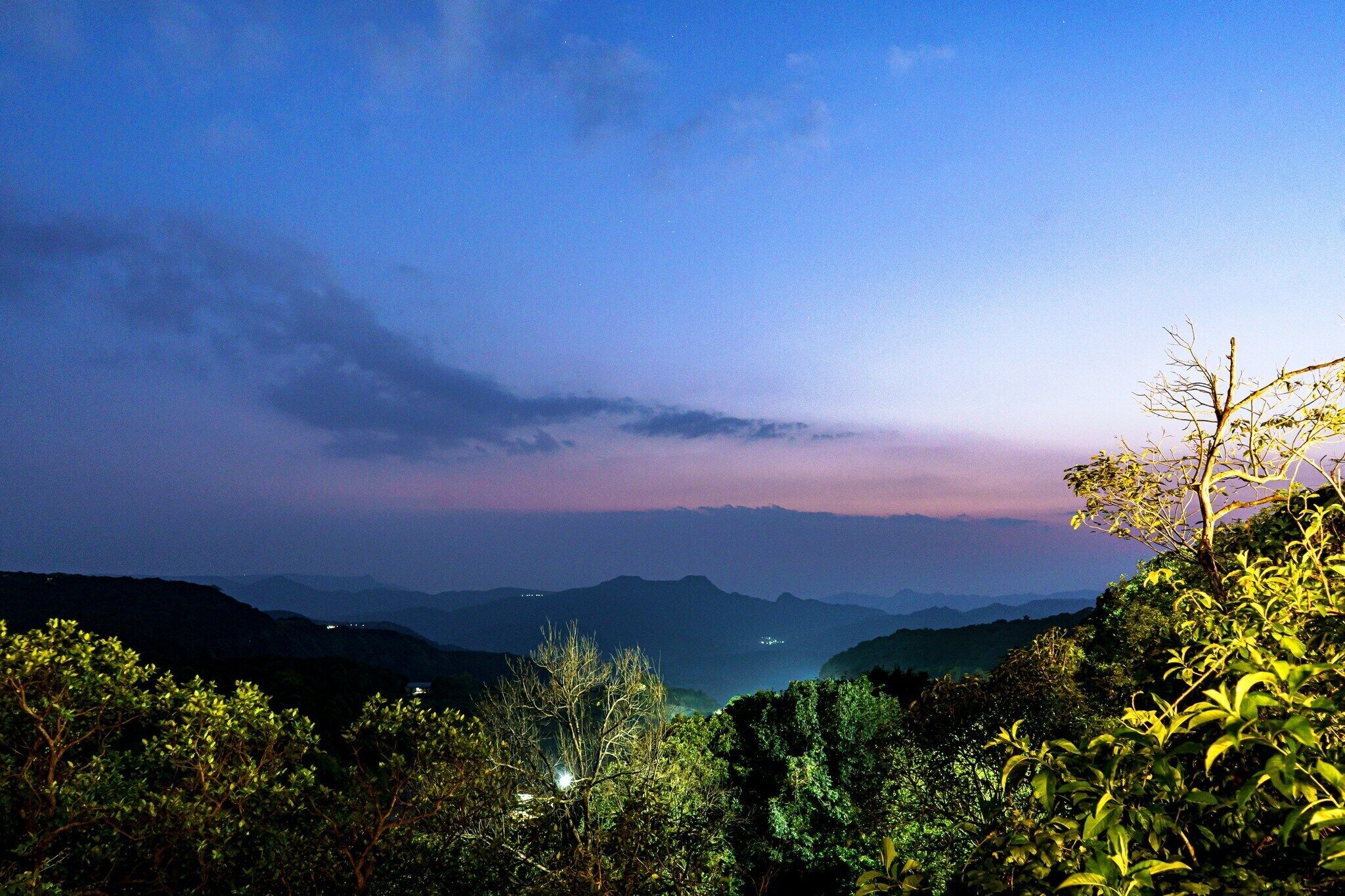 A mountainous landscape with a view of distant hills and a clear sky.