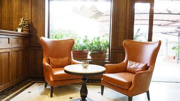 A room with two leather armchairs facing a round table with a small decorative item on it.