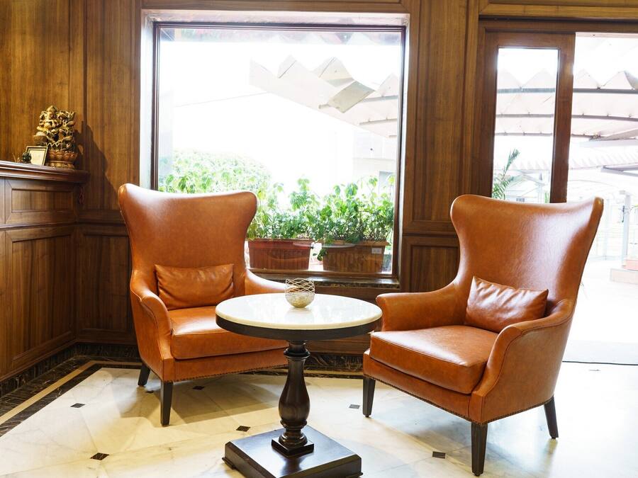 A room with two leather armchairs facing a round table with a small decorative item on it.