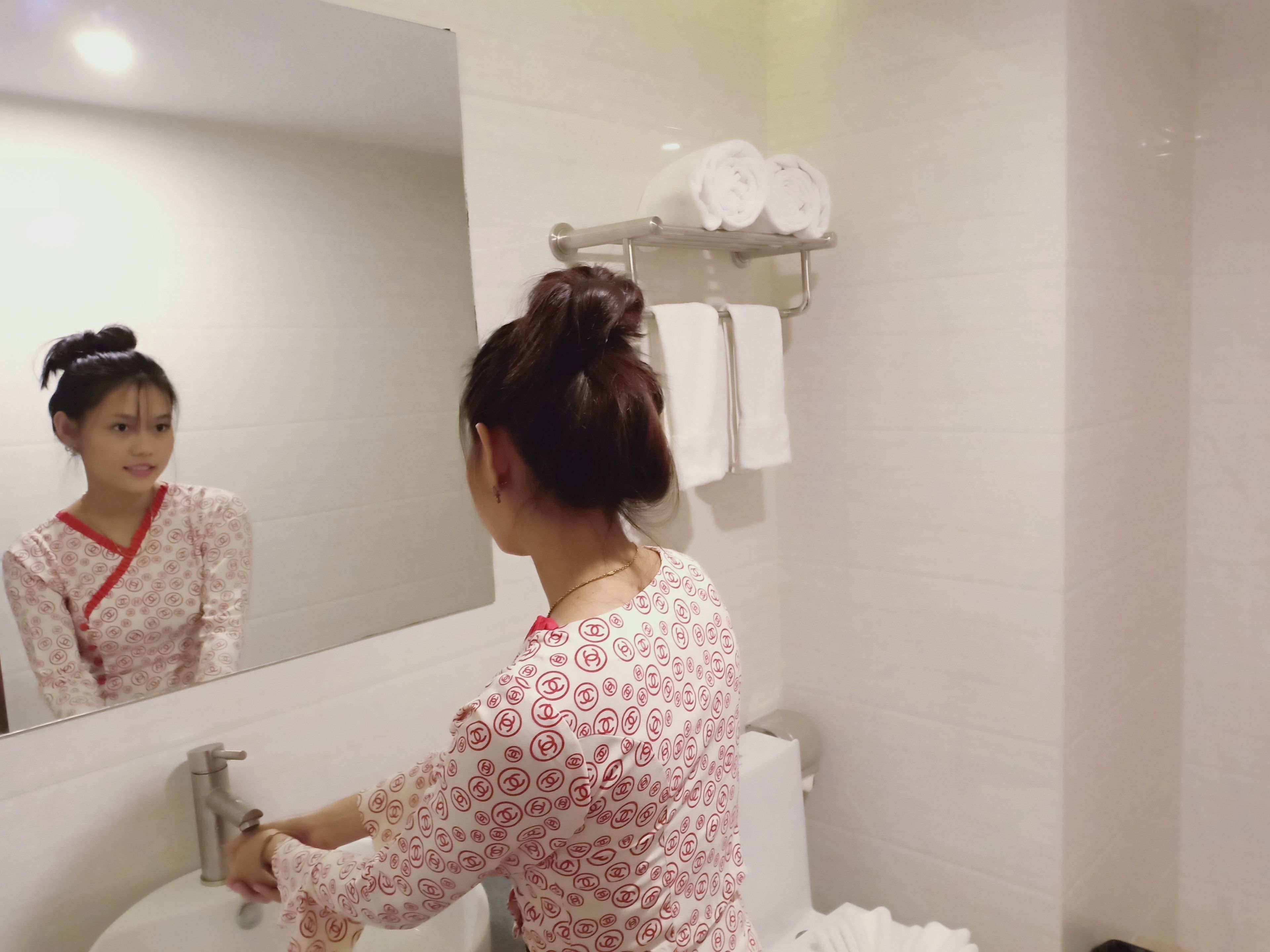 A bathroom with a sink, mirror, and towel rack.