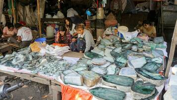 A market stall with various green and white stones displayed on a table.