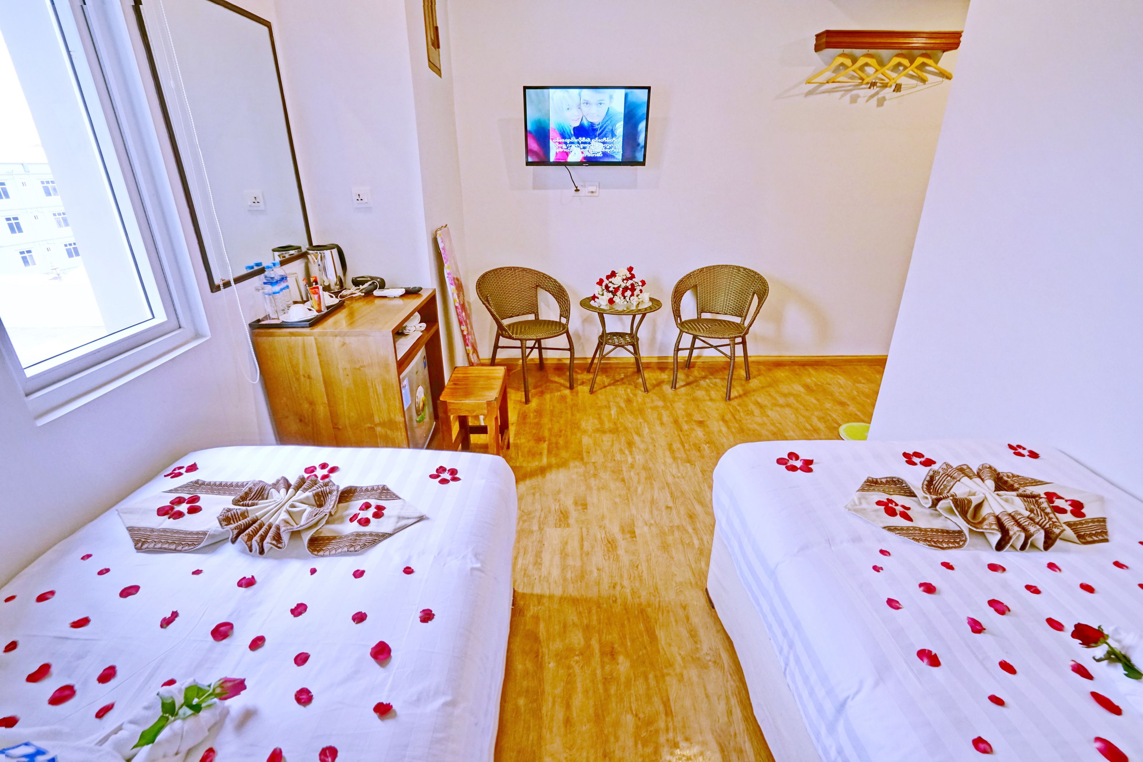 Une chambre d’hôtel avec deux lits, une télévision, un bureau et une chaise.
