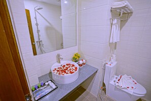 A bathroom with a sink, mirror, shower, and toilet. - Hotel Duo Swan (Mandalay)