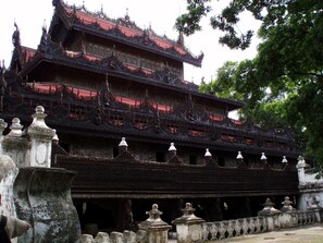 A multi-tiered temple with intricate carvings and a red roof. - Hotel Duo Swan (Mandalay)