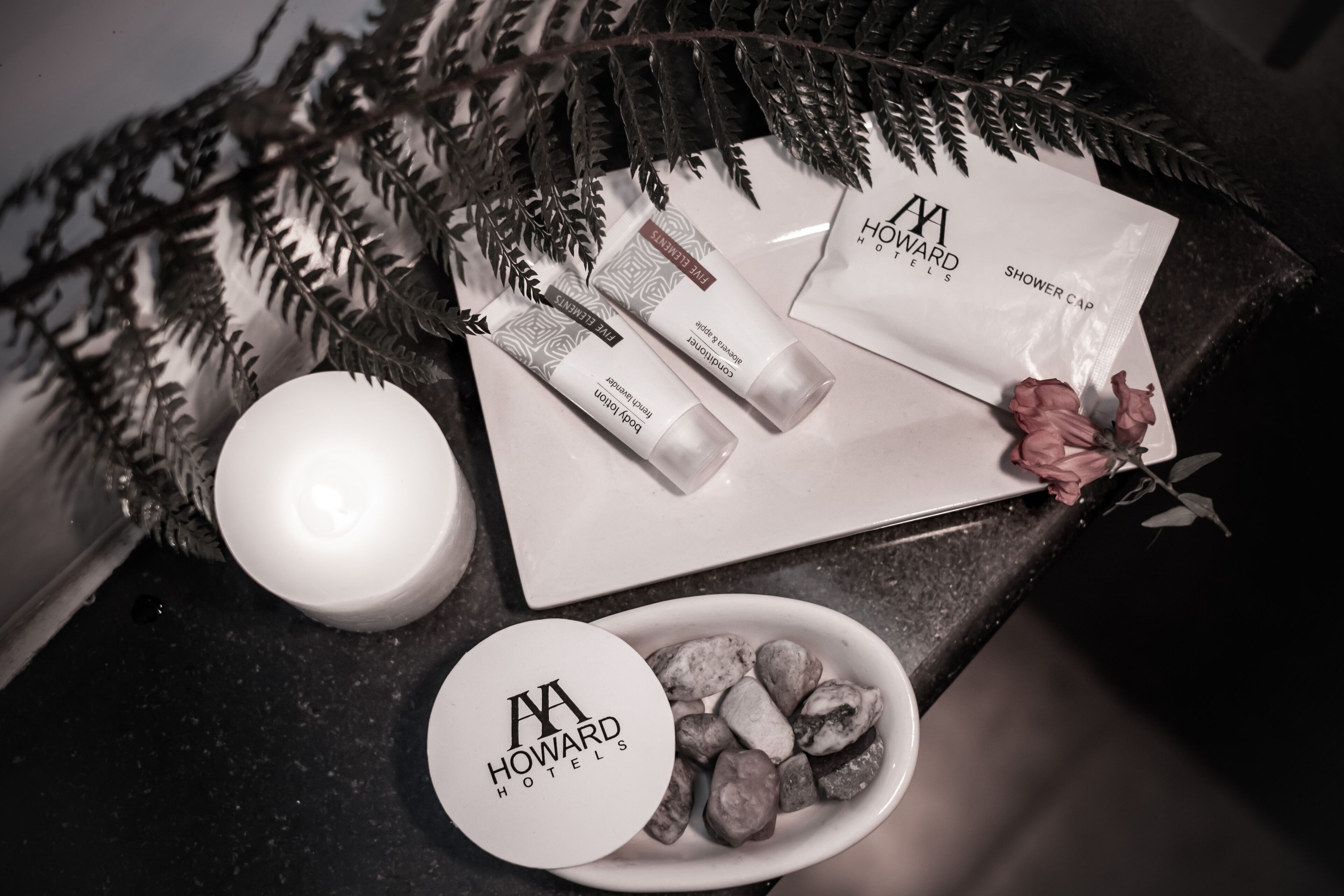 A tray with toiletries, a candle, and a decorative fern.