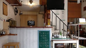 Un petit restaurant chaleureux, avec un décor intérieur en bois, un menu écrit à la craie et un téléviseur fixé au mur.