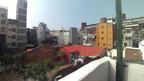 Une vue urbaine comprenant divers bâtiments, notamment une construction à toit rouge et un bâtiment jaune.