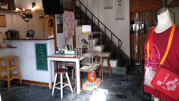 L’intérieur d’un restaurant, avec un comptoir, des tabourets, un escalier et un mannequin.