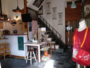 L’intérieur d’un restaurant, avec un comptoir, des tabourets, un escalier et un mannequin.