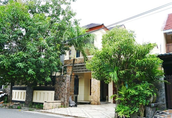 A residential house with a gated entrance, surrounded by lush greenery and a tiled pathway. - Green Surabaya Homey (Surabaya)