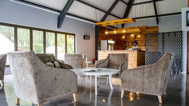 A modern interior with a bar area, large windows, and plush seating. - Mount Shekinah Country Hotel (Balgowan)
