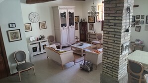 Un soggiorno accogliente con un mobile bianco, due poltrone, un tavolino e un lampadario.