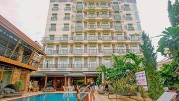 Alberca al aire libre, sombrillas en la alberca y camastros