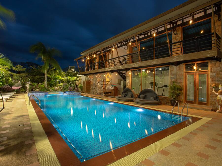 Una piscina al aire libre, sombrillas, sillones reclinables de piscina