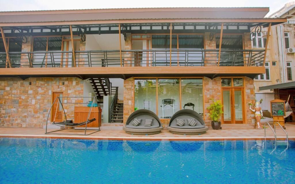 A two-story building with a swimming pool in front.