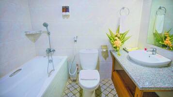 A bathroom with a bathtub, toilet, sink, and a mirror.