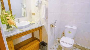 Ein Badezimmer mit Waschbecken, Spiegel, Handtuchhalter und Toilette.