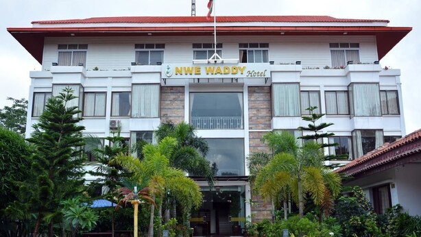L’hôtel NWE WADDY, reconnaissable à son toit rouge, à ses nombreuses fenêtres et à son drapeau.