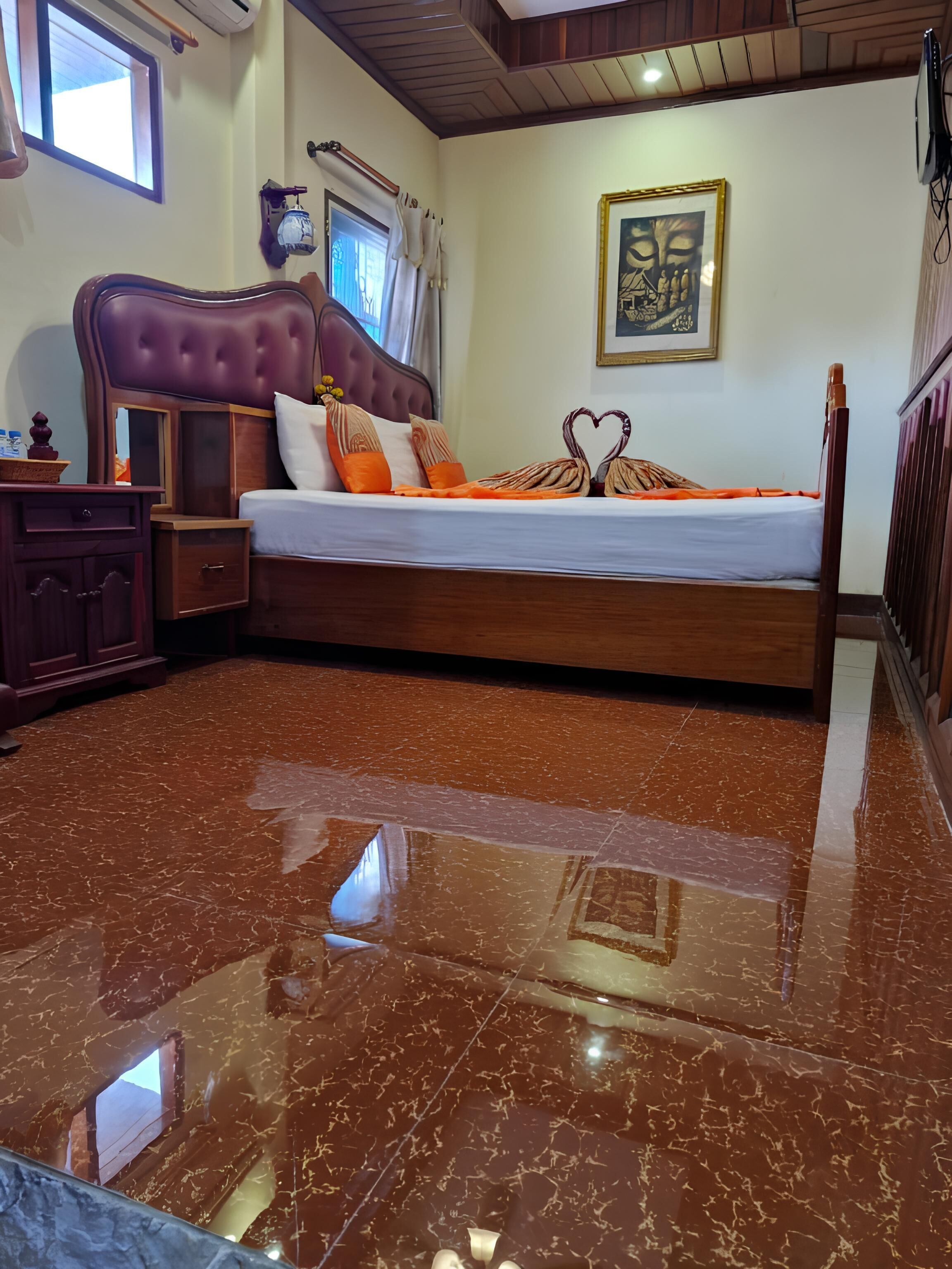 A bedroom with a marble floor, a wooden bed frame, and a headboard.