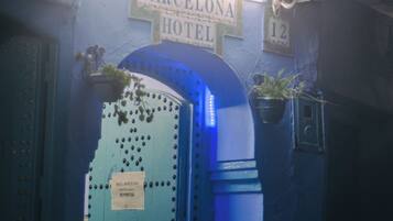 Una puerta azul con un letrero que dice "BARCELONA HOTEL" y el número "12" encima.