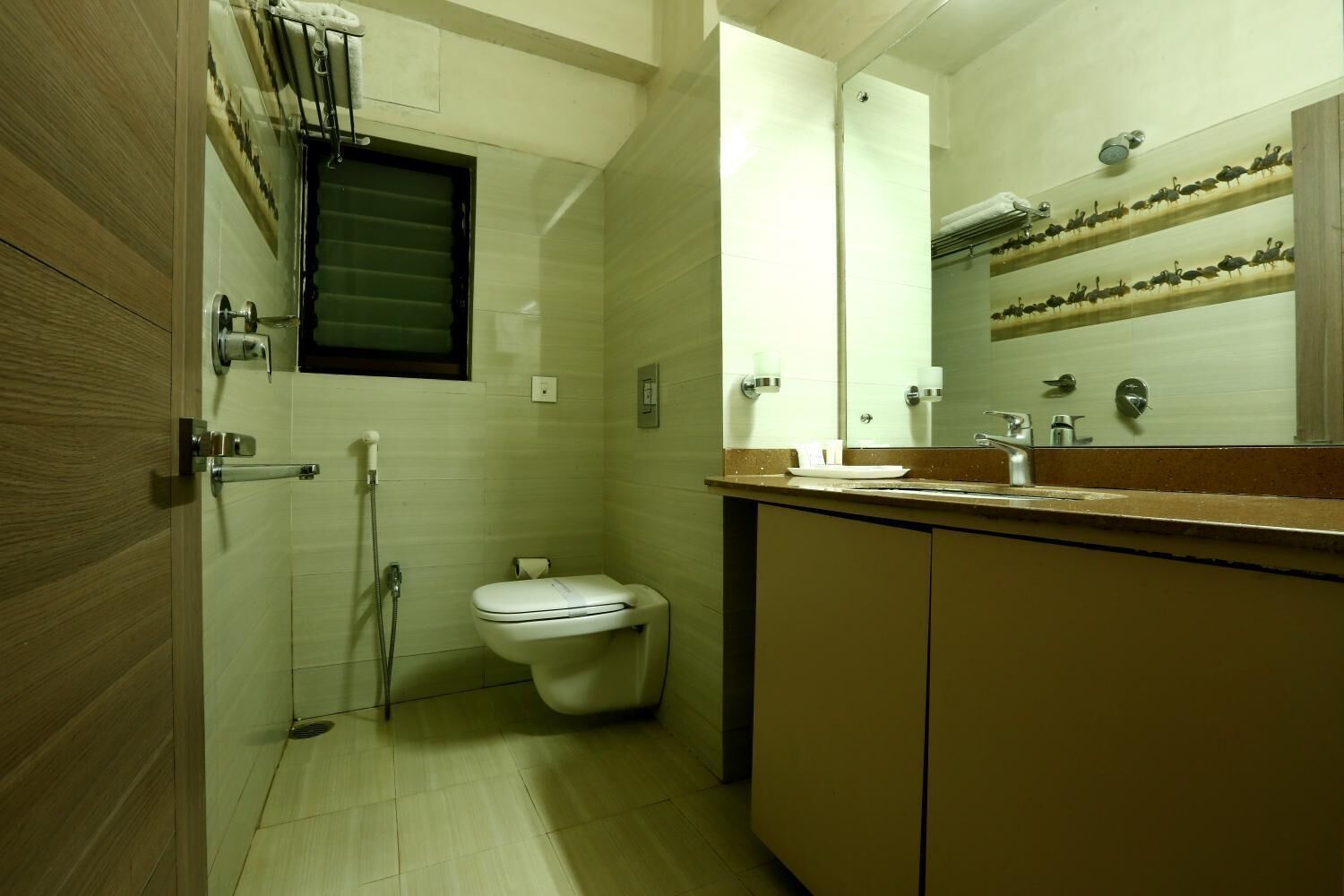 A compact bathroom with a toilet, a shower, and a sink.