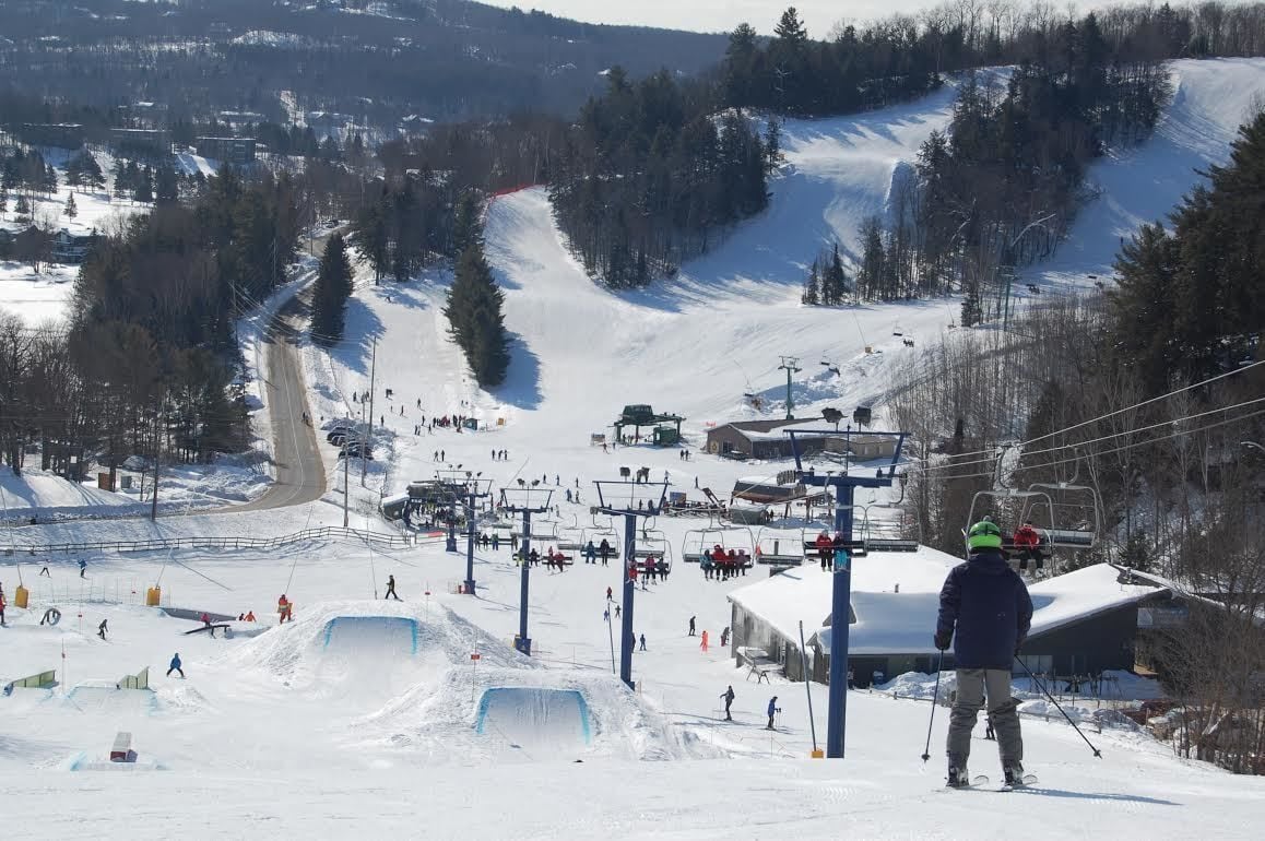Un centro de esquí con telesilla, pistas de nieve y un paisaje nevado.