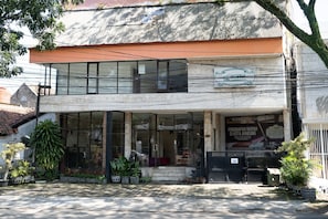 A two-story building with a glass storefront and a sign advertising a discount management service. - Wisma Asia Busindo Syariah (Bandung)