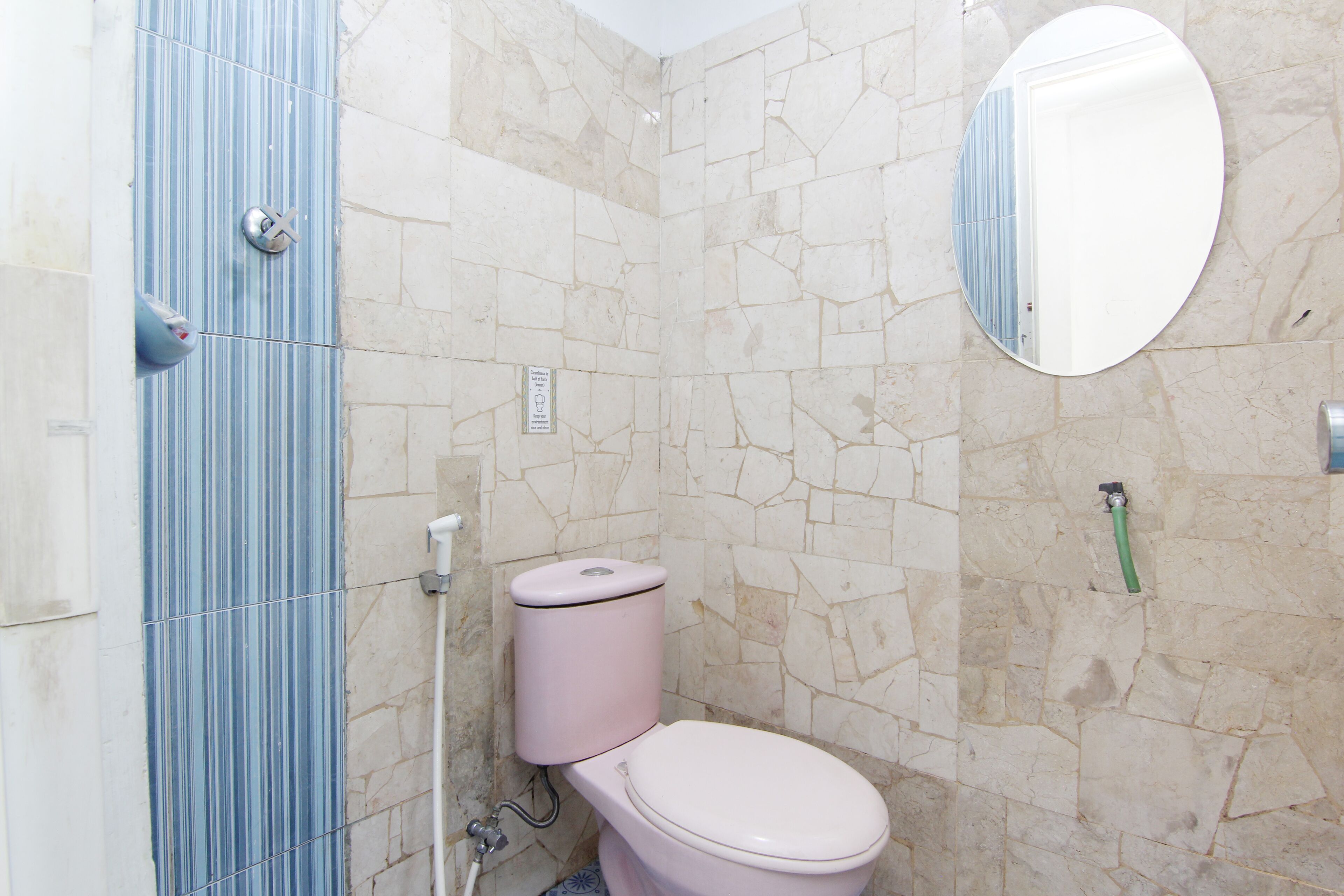 Un baño con inodoro, espejo y zona de ducha.