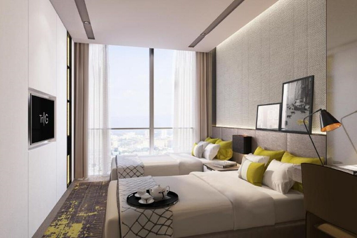 Et moderne hotelværelse med et stort vindue, en seng, et skrivebord og et fjernsyn.