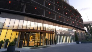 A modern hotel with a prominent glass facade, a multi-story structure, and a well-lit entrance area. - Centro Westside by Rotana (Istanbul)