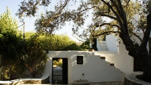 Un bâtiment blanc avec un escalier en pierre menant à une porte.