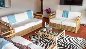 A living room with two white sofas, wicker armchairs, a glass coffee table, and a zebra-patterned rug. - Design Apartments mit Terrasse - Adults Only (Innsbruck)