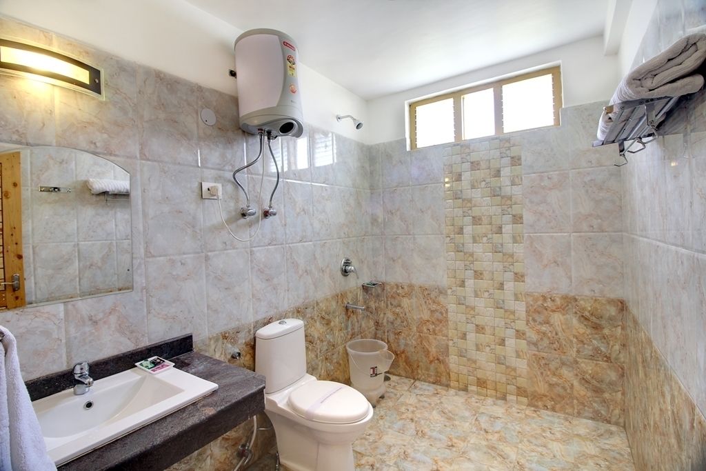 Een badkamer met een marmeren wastafel, toilet en douchehoek.