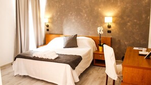 A hotel room with a bed, bedside tables, a desk, and a chair. - Aquam Albergo (Acqui Terme)