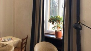 A room with a window, a chair, a table, and a potted plant. - Aquam Albergo (Acqui Terme)