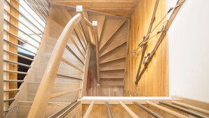 A spiral staircase with wooden railings and a wooden ceiling. - The Kaprun Edition (Kaprun)