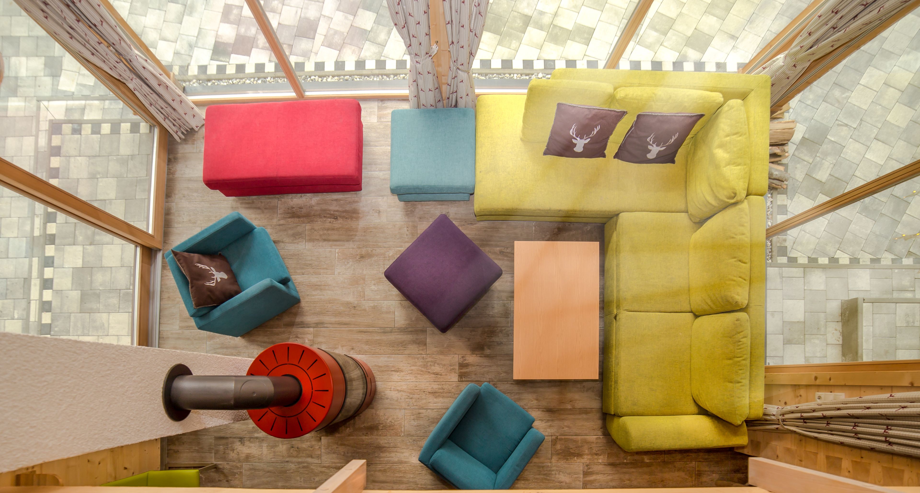 Un interior moderno con un sofá modular, varios otomanes y un diseño de techo original.