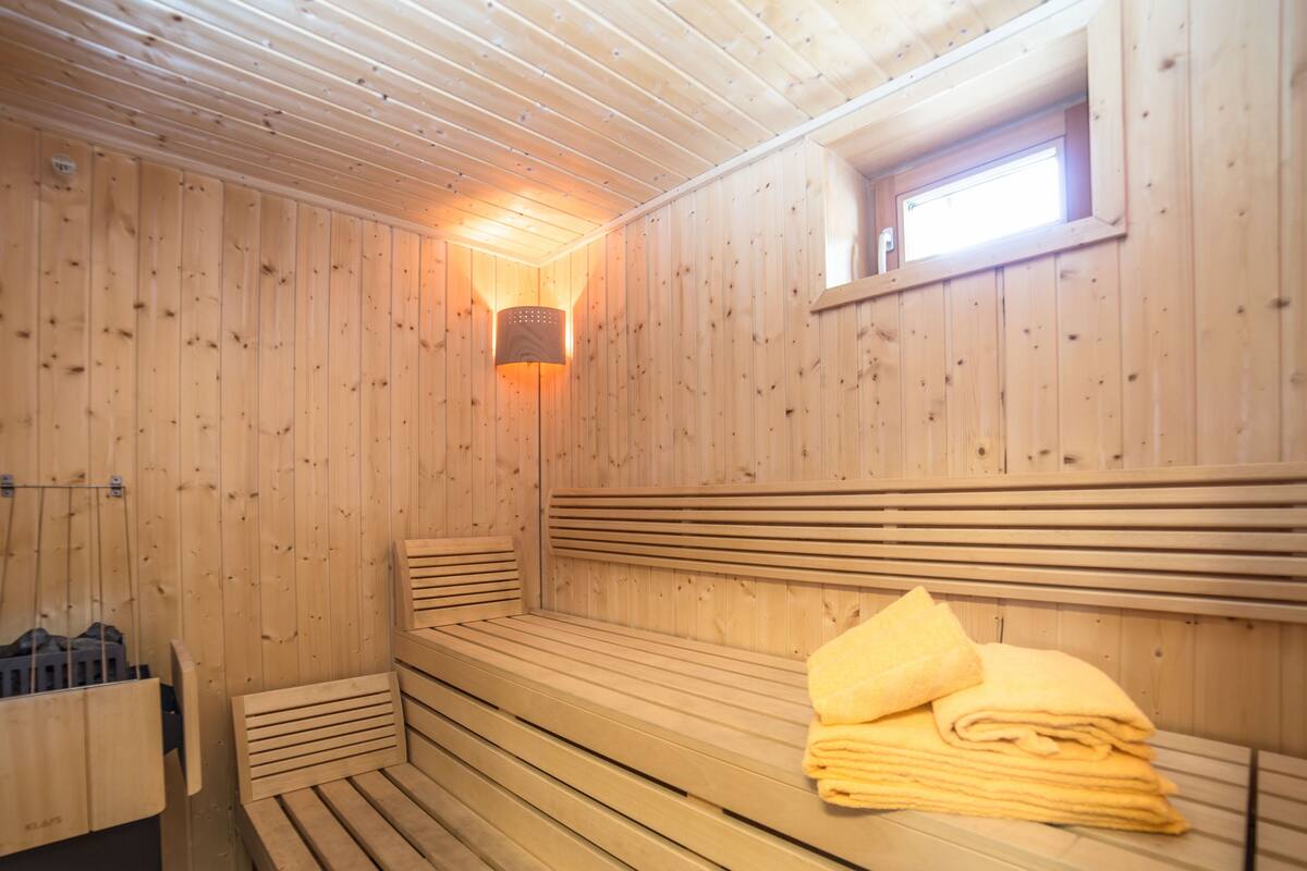A sauna room with wooden benches and a small window.